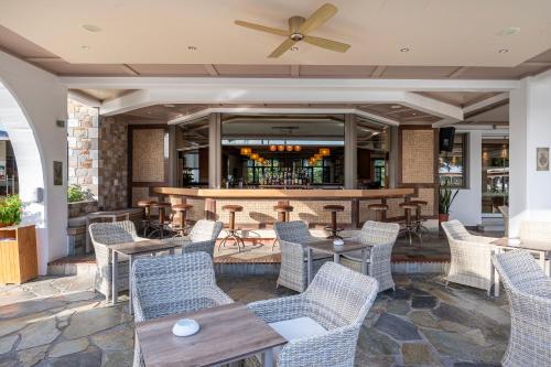 a restaurant with tables and chairs and a bar at Palladium hotel in Marmari