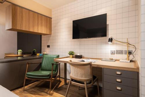 a room with a desk with chairs and a tv at Dash Living on Hollywood in Hong Kong