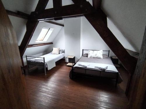 ein Schlafzimmer im Dachgeschoss mit 2 Betten und einem Fenster in der Unterkunft Nor50 - Pont Farcy - Chalet Papillon in Pontfarcy