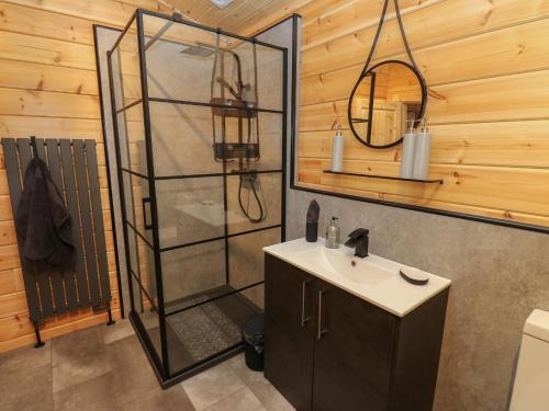 a bathroom with a shower and a sink at Height End Farm Log Cabin in Bacup