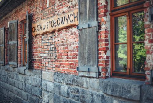 a brick building with a sign on the side of it at Chata w Stołowych in Łęzyce
