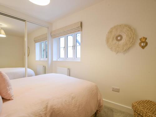 a bedroom with a white bed and a mirror at 22 Applebee Way in Lyme Regis