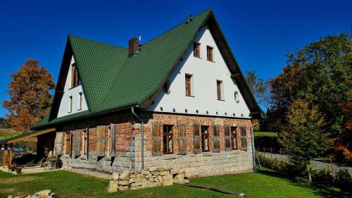 a large white house with a green roof at Chata w Stołowych in Łęzyce