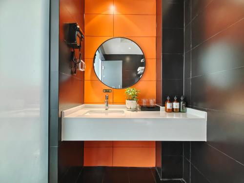 een badkamer met een wastafel en een spiegel bij Nan'er Jieli Hotel - Chengdu Tianfu International Airport Branch in Jianyang