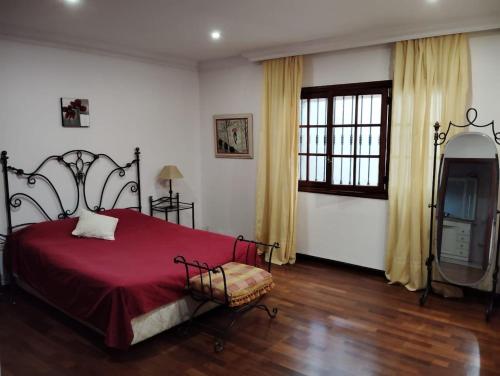 1 dormitorio con cama roja y TV en Espectacular Villa con piscina y vistas al valle en Cruz Santa