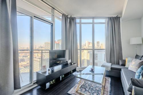 sala de estar con sofá y ventana grande en GLOBALSTAY. Elegant Downtown Apartments en Toronto