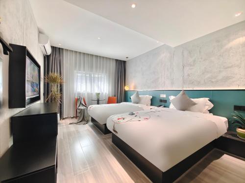 een hotelkamer met 2 bedden in een kamer bij Nan'er Jieli Hotel - Chengdu Tianfu International Airport Branch in Jianyang