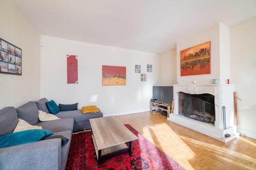 uma sala de estar com um sofá e uma lareira em Home - Hubert Fabureau - Séjour à Auxerre em Auxerre
