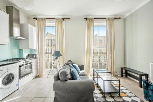 a living room with a couch and a kitchen at Central London Gem: Modern&Cozy in London