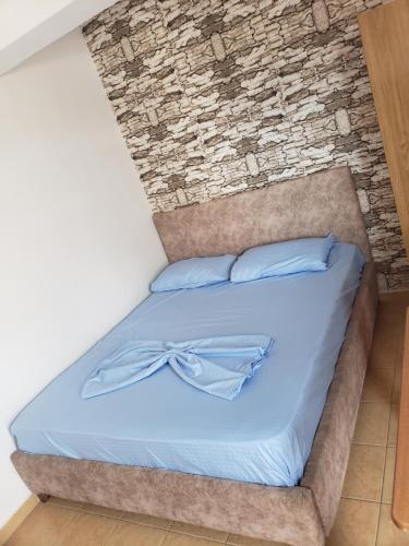 Bett in einem Zimmer mit Ziegelwand in der Unterkunft Hotel Rozafa Velipoje in Velipojë