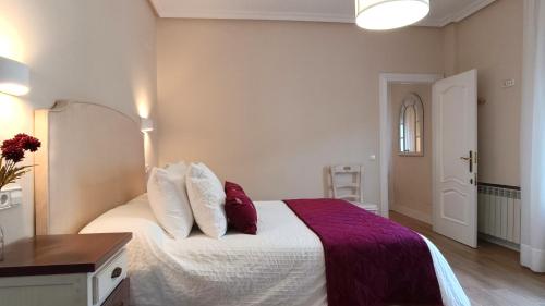 a bedroom with a bed with red and white pillows at Ciudad del encaje 2 in Almagro