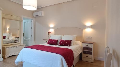 1 dormitorio con 1 cama blanca grande con almohadas rojas en Ciudad del encaje 2, en Almagro