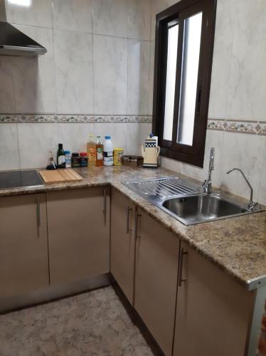 a kitchen counter with a sink and a window at piso con desayuno incluido y vistas a la montaña. in Monistrol