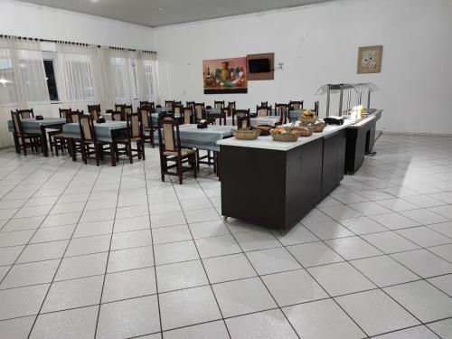 un comedor con mesas y sillas con comida. en PORTAL PARQUE HOTEL, en Francisco Beltrão