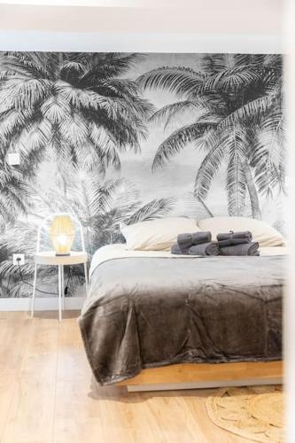 - une chambre avec un lit orné d'une fresque murale de palmiers dans l'établissement Jungle Room de Charme, à Marseille