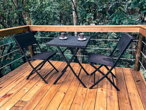 una mesa negra y 2 sillas en una terraza de madera en La Chagra VIP, en Villavicencio
