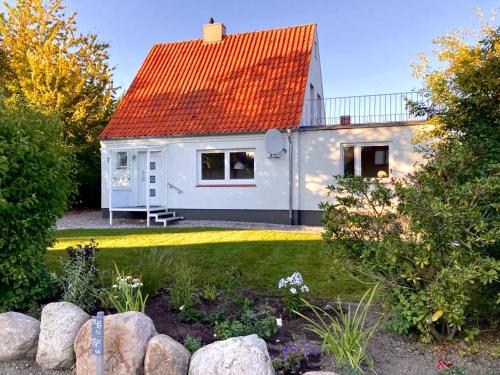 a small white house with an orange roof at StrandGlück in Kleinwaabs