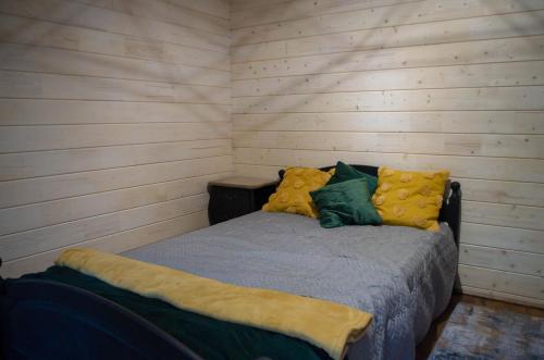 Ce lit se trouve dans un dortoir doté de murs en bois. dans l'établissement Jausa metsamaja, à Jausa