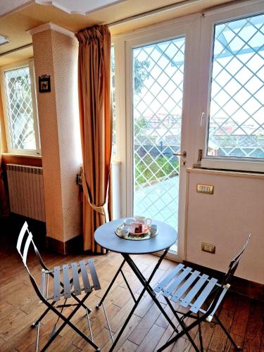 a table and chairs in a room with a window at Fuga a Napoli Apartment in Naples