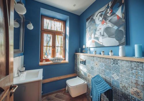 a blue bathroom with a toilet and a sink at Chata w Stołowych in Łęzyce