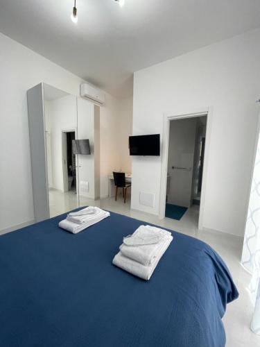 a bedroom with a blue bed with two towels on it at Holden House in Bari