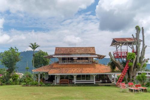 a house with a red ladder on top of it at Hilltop Camp by TwoSpaces, Lembang in Lembang