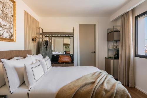 a bedroom with a large white bed with white pillows at Casa de las Artes, member of Meliá Collection in Madrid