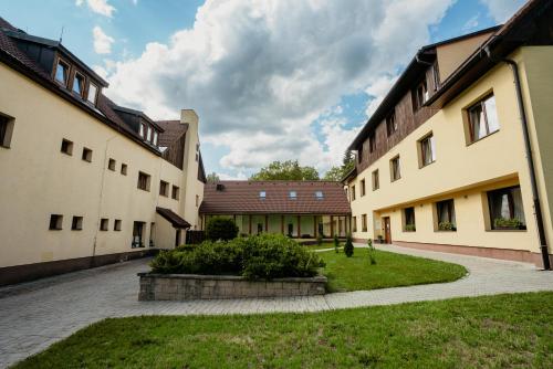 a courtyard of two buildings with a grass yard at Amantis Vital Sport Hotel in Desná