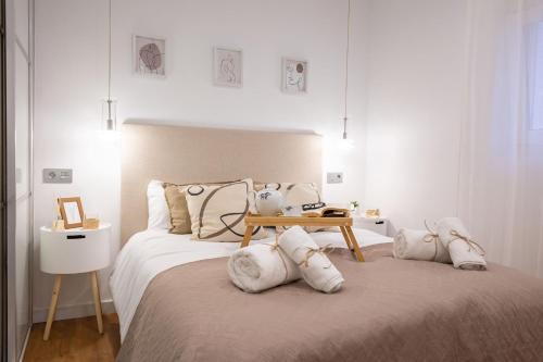 - une chambre blanche avec un grand lit et des oreillers blancs dans l'établissement El Refugio de Emma, à Séville