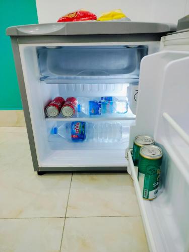 an open refrigerator filled with drinks and sodas at Adventure Hotel in Ho Chi Minh City