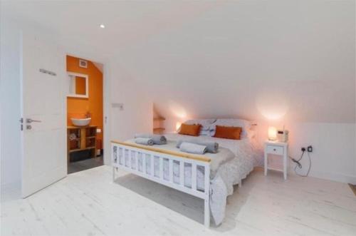 a bedroom with a large white bed and a bathroom at The Hideout, Braunton, Devon in Braunton