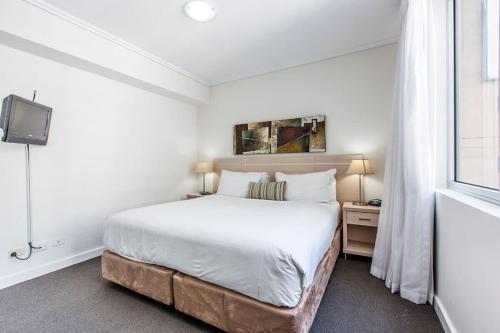 - une chambre blanche avec un lit et une fenêtre dans l'établissement Brisbane Casino Tower Luxury Suites, à Brisbane