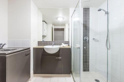 La salle de bains est pourvue d'un lavabo et d'une douche. dans l'établissement Brisbane Casino Tower Luxury Suites, à Brisbane