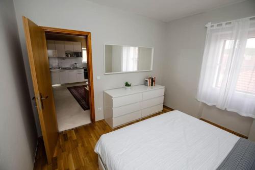 Apartment Old Town - Bambo في كنين: غرفة نوم بسرير ابيض وخزانة بيضاء
