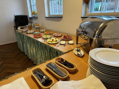 a table with plates and bowls of food on it at Hotel Krasnoludki in Sosnówka