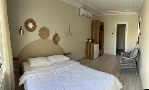 a bedroom with a white bed and a chair at Kingway Suite in Nusratlı