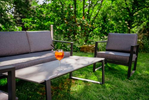 a glass of wine on a table with two chairs at Amantis Vital Sport Hotel in Desná