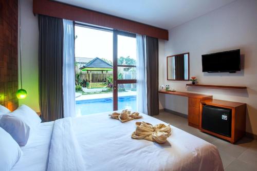 a hotel room with a bed with towels on it at Pudak Sari Unizou in Kuta