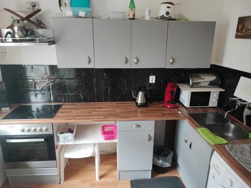 uma cozinha com armários brancos e um balcão de madeira em Zum Flughafen em Dusseldorf