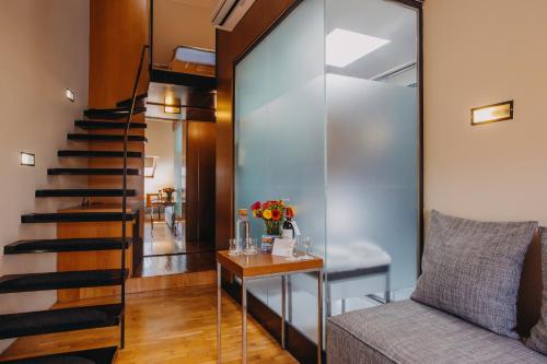 a staircase in a room with a couch and a table at Wenceslas Square Hotel - Czech Leading Hotels in Prague