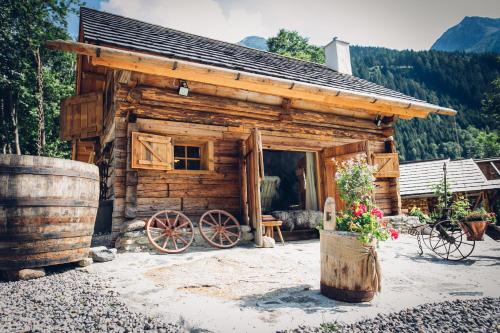 フラタッハにあるRomantikchaletのベンチとワゴン付きのログキャビン