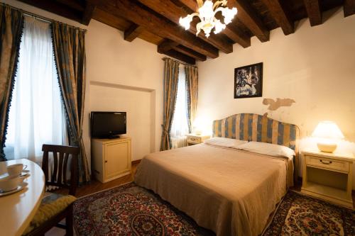 a bedroom with a bed and a tv and curtains at Furlani Apartments in Venice