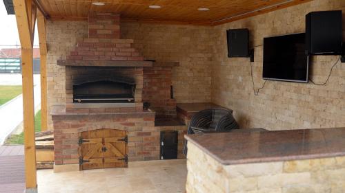 a brick fireplace with a pizza oven in a patio at Pensiunea LOTUS Smardan 