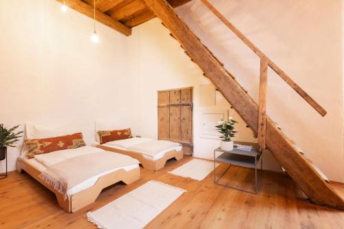 a attic bedroom with two beds and a staircase at Siebensternehaus in Steyr