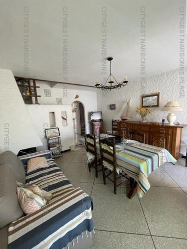 une chambre avec deux lits, une table et un bureau dans l'établissement Maison avec jardin sur SAINT PIERRE LA MER 6STP73, à Saint Pierre La Mer