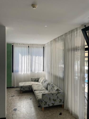 uma sala de estar com um sofá em frente a uma janela em Hotel Rosa em Rimini