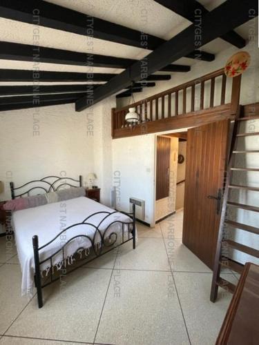 une chambre avec un lit au milieu d'une pièce dans l'établissement Maison avec jardin sur SAINT PIERRE LA MER 6STP73, à Saint Pierre La Mer