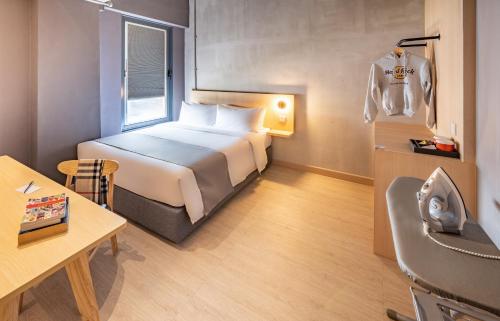 a hotel room with a bed and a table and a chair at BRIX KLIA By Pinetree in Sepang