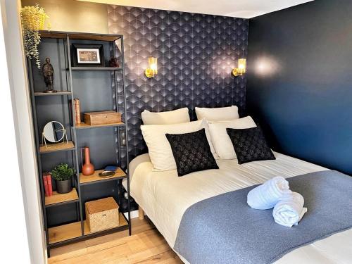 1 dormitorio con cama y pared azul en Home - Le repère des sommeliers, en Auxerre