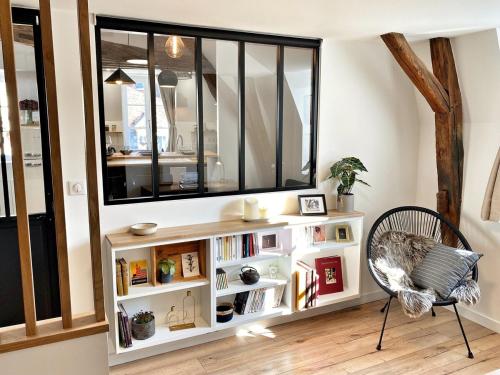 a room with a book shelf and a chair at Le repère des sommeliers - Sejour a Auxerre in Auxerre